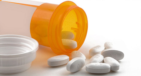 Pills half out of an orange bottle
